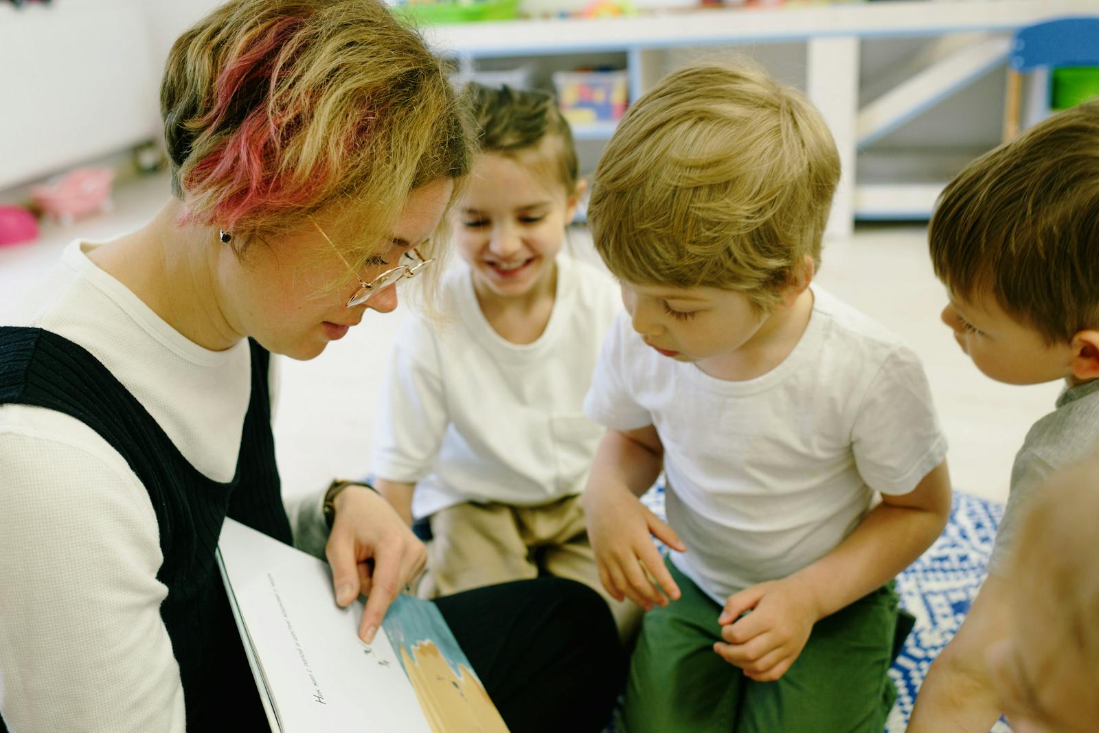 A woman reading a picture book to a child — calm focus, shared attention